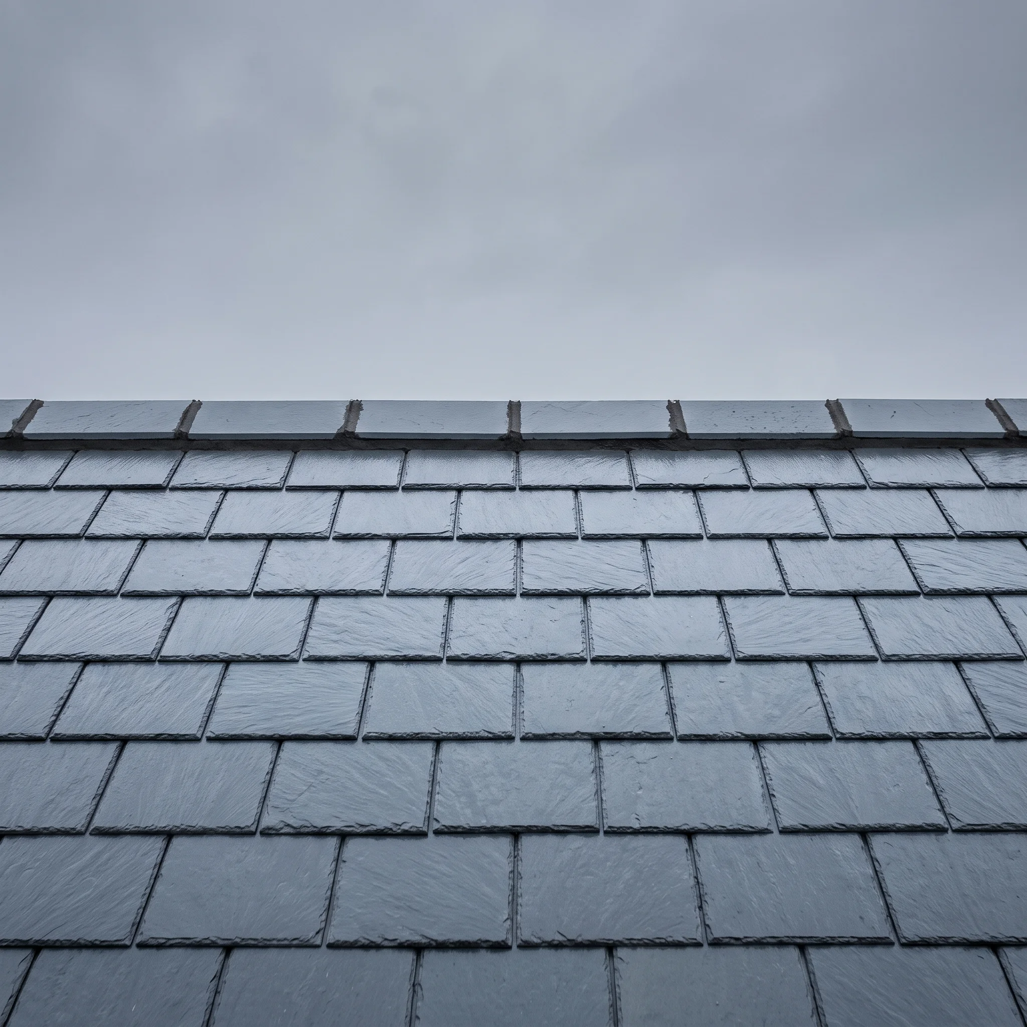 Finished slate ridge line running straight against a flat grey sky